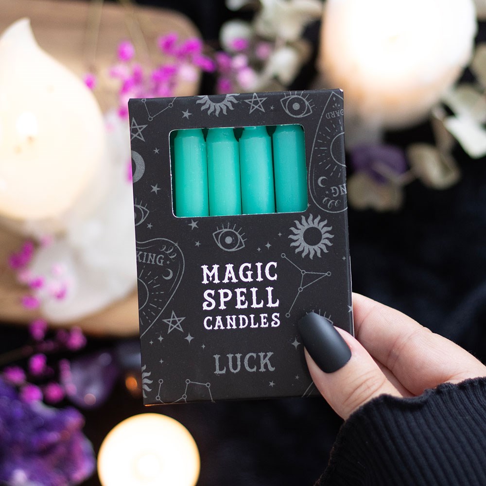 Pack of turquoise 'Magic Spell Candles Luck' with decorative packaging held by a hand.
