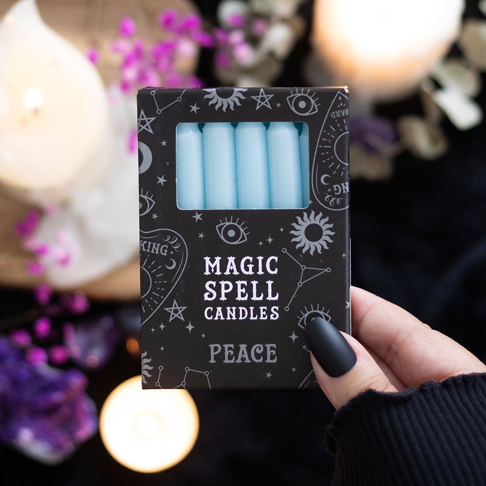 Box of 'Magic Spell Candles Peace' with a hand holding it against a blurred background.