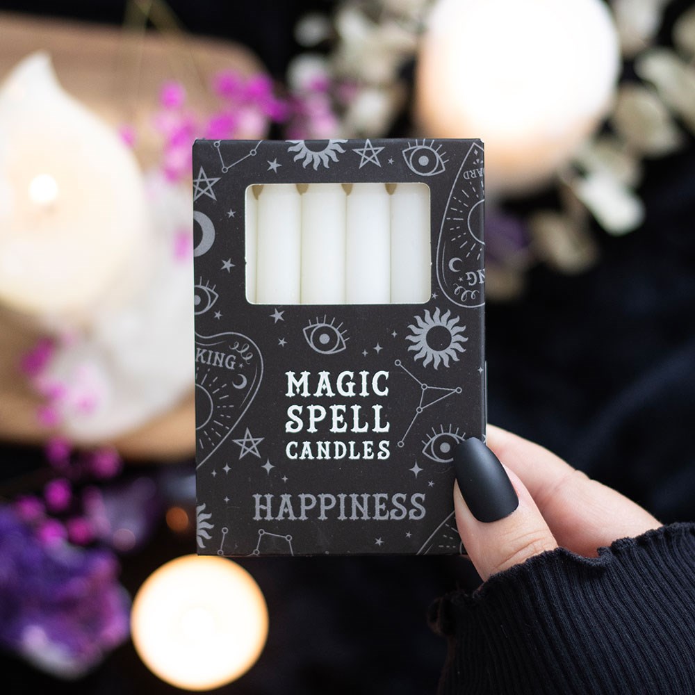 Box of 'Magic Spell Candles Happiness' with mystical symbols on a blurred background